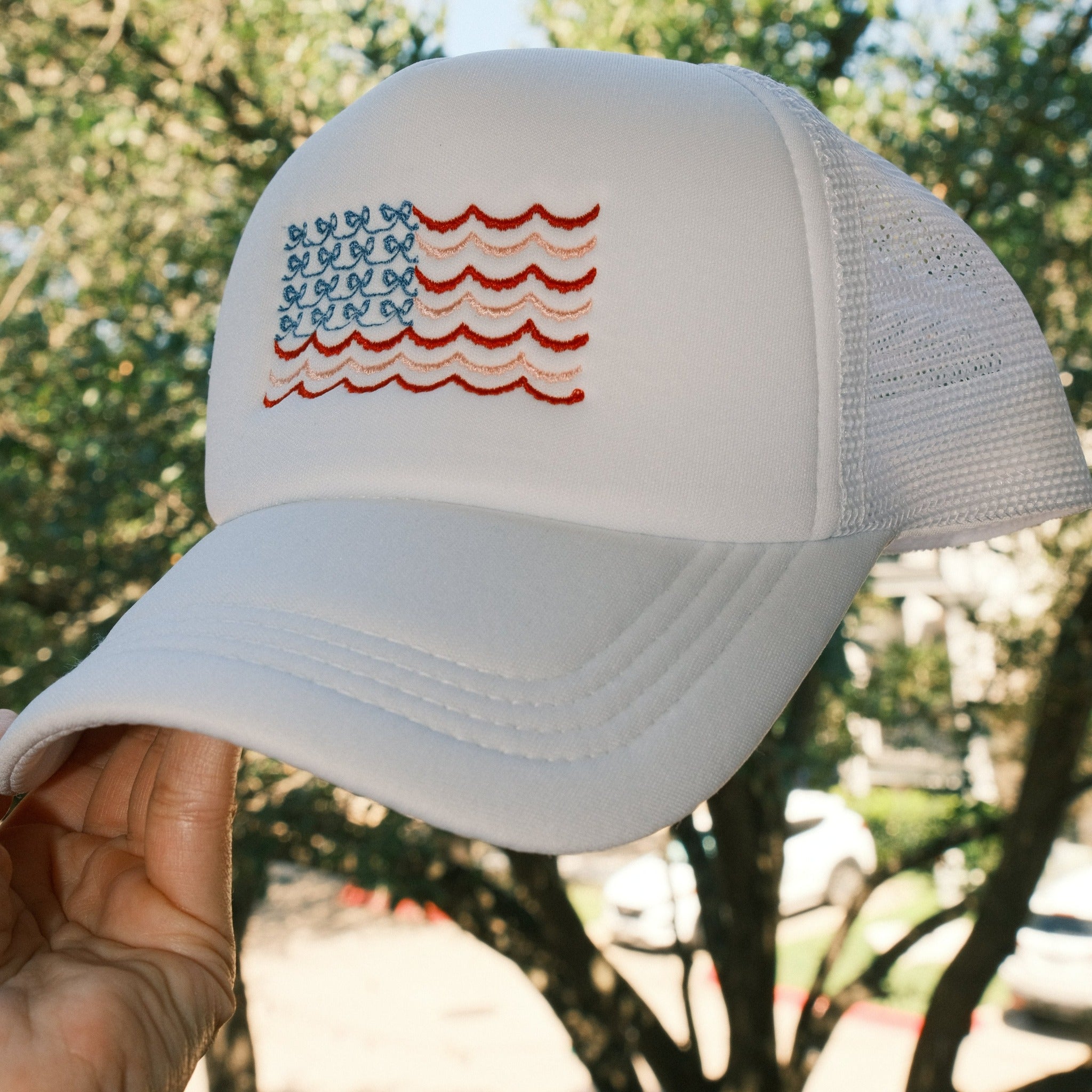 Coquette Bow American Flag embroidered on white trucker hat side view